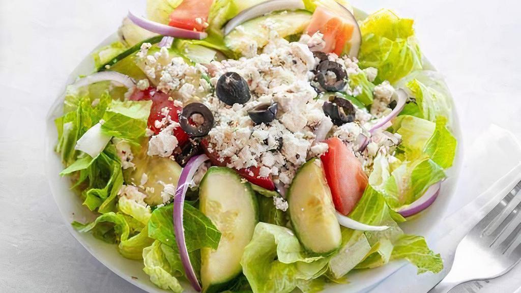 Greek Salad · Crisp Romaine tossed in our creamy Greek Feta vinaigrette, topped with crunchy cucumbers, ripe tomatoes, shaved red onions, sliced Kalamata olives, and crumbled Feta cheese
