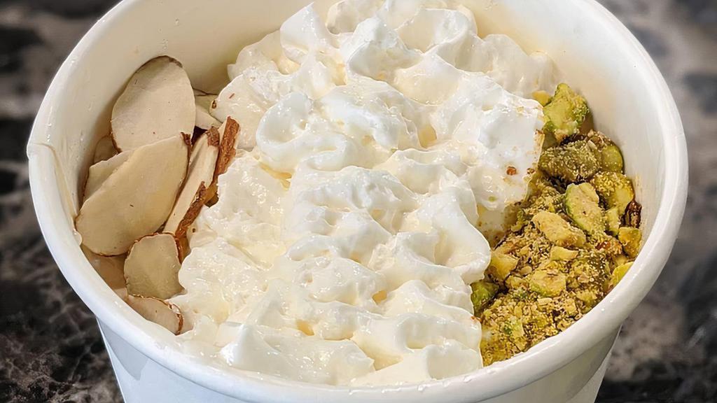 Mehliyaeh Pudding (Qty 1) · creamy, sweet milk pudding with hints of rosewater. topped with whipped cream, pistachio, and almonds.