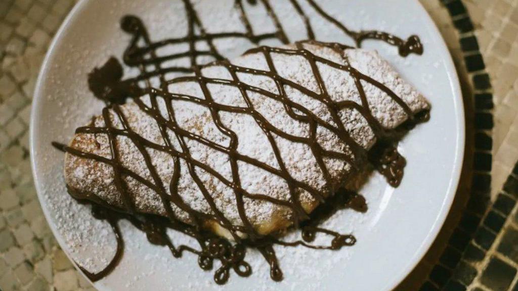 Dessert Calzone · Calzone stuffed with honey ricotta, drizzled with Nutella, powdered sugar, and sea salt.