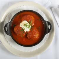 Homemade Meatballs · Three beef meatballs in a light tomato sauce with a scoop of ricotta.