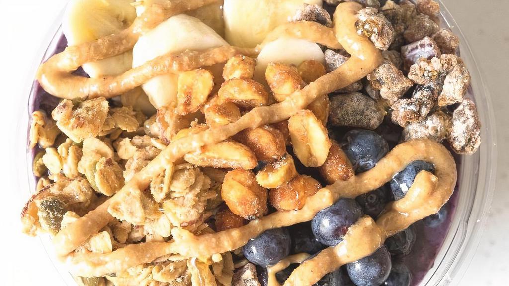 Pb + B · Blend of açai, banana, blueberry, peanut butter, almond milk topped with banana, blueberry, honey roasted peanut butter, chopped dates, peanuts, granola.