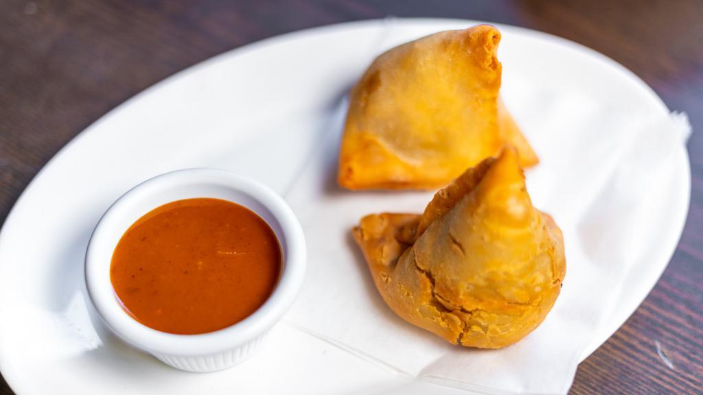 Samosa · Crispy pastry stuffed with spiced potatoes, and peas.