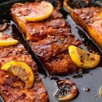 Honey Garlic Glazed Salmon · Pan seared salmon cooked to perfection with a honey garlic drizzle. with 2 sides.