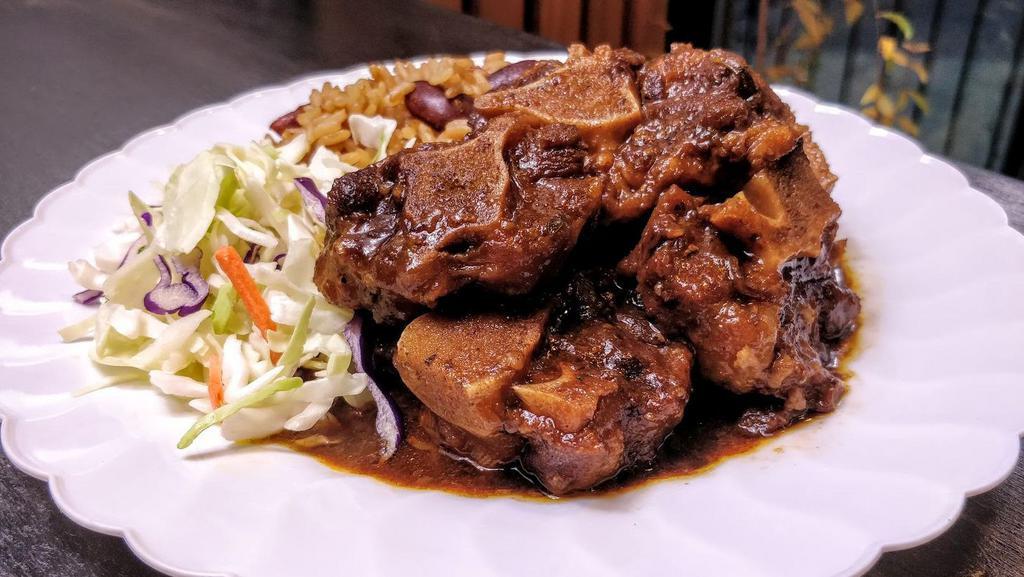 Oxtail With Rice & Beans · Stewed and simmered, tender, bone-in oxtail, served on seasoned rice, cooked with kidney beans. Comes with cabbage.