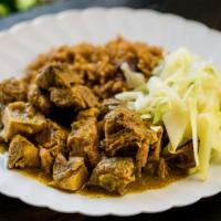 Curry Goat With Rice & Beans · Slow cooked, tender, bone-in curried goat, served on seasoned rice, cooked with or kidney be...