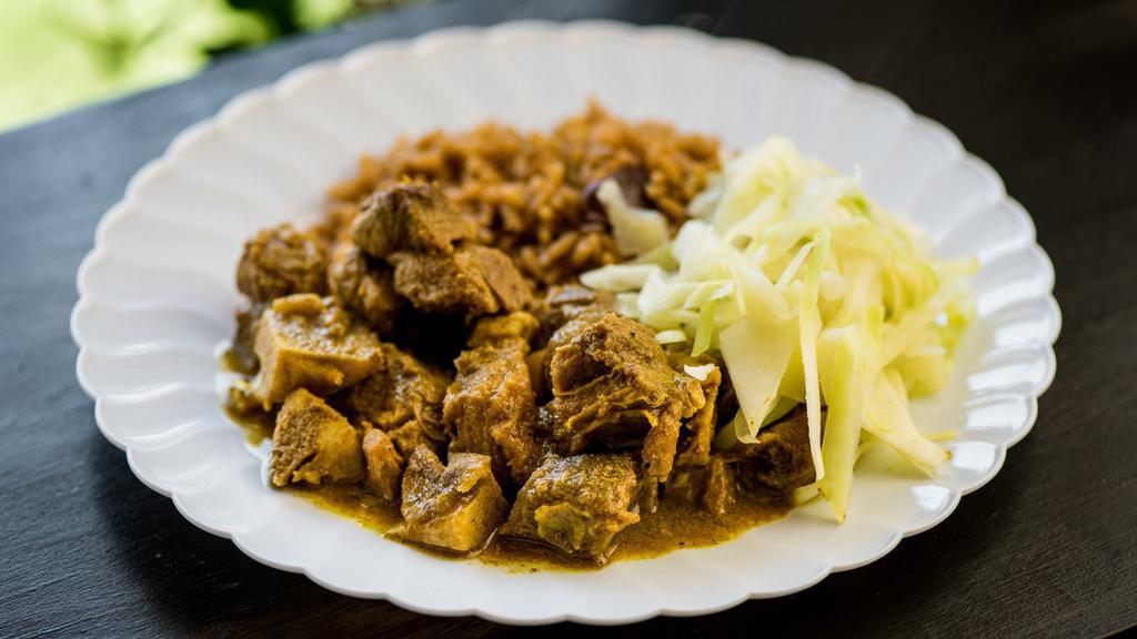 Curry Goat With Rice & Beans · Slow cooked, tender, bone-in curried goat, served on seasoned rice, cooked with or kidney beans. Comes with cabbage.