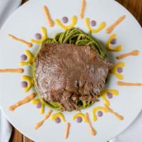 Tallarin Verde Con Bisteck · Our famous aji marinated skirt steak placed on a bed of our own homemade Peruvian pesto sauc...