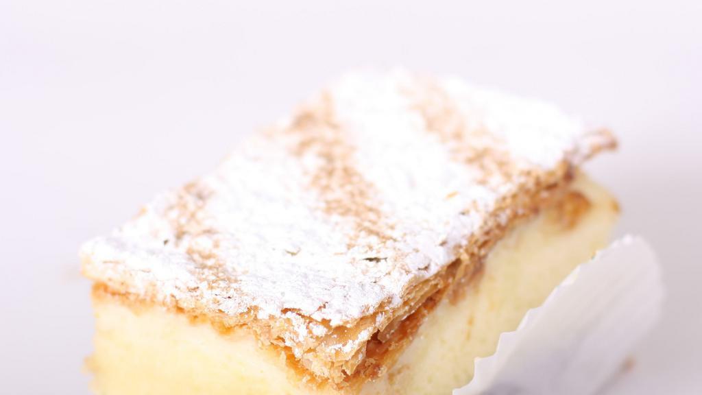 Old Fashion Napoleon · Vanilla cake soaked in a bakers rum filled with our rich vanilla and chocolate custard topped with a flaky pastry top with powdered sugar on top.