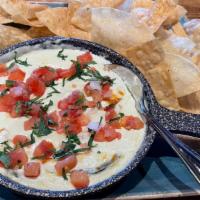 Queso Fundido · creamy poblano rajas baked with our three cheese blend and topped with pico de gallo and fre...