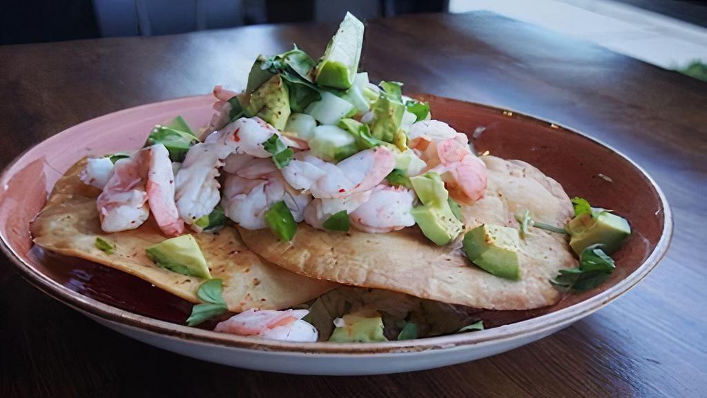 Shrimp Ceviche · Large shrimp marinated in fresh lime juice, jalapeños, cucumber, cilantro, and topped with diced avocado, served with made to order fried tostadas.