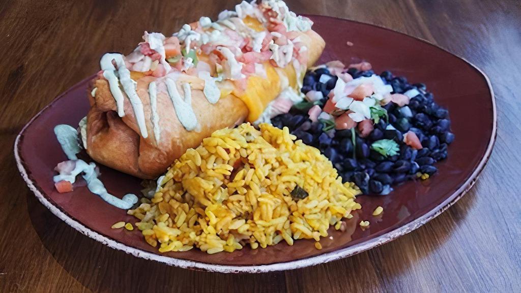 Chimichanga · deep fried flour tortilla stuffed with blackened chicken, rice, black beans and melted cheddar jack cheese, topped with pico de Gallo and cilantro cream, served with a side of rice & beans