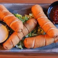 Taquinos Con Queso · buttery pastry wrapped around queso fresco, served piping hot with warm fire roasted tomato ...
