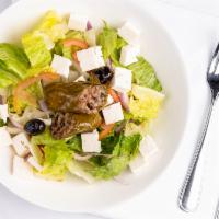 Greek Salad · Lettuce, tomatoes, onions, feta cheese, grape leaves, olive oil and lemon juice.