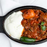 Iskender Kebab · Doner kebab served over pan sauteed pita bread topped with fresh tomato sauce and served wit...