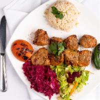 Lamb Shish Kebab · Char-grilled cubes of lamb, served with rice and vegetables.