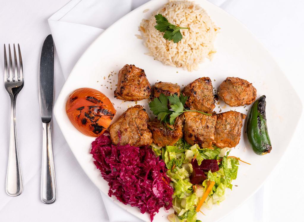 Lamb Shish Kebab · Char-grilled cubes of lamb, served with rice and vegetables.