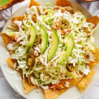 Tex Mex Nachos · Crispy corn tortilla topped with refried beans lettuce ,tomatoes,sour cream , cheese ,avocad...