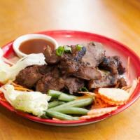 Kor Moo Yang · Grill marinated pork neck w/ spicy tamarind lime dipping sauce.