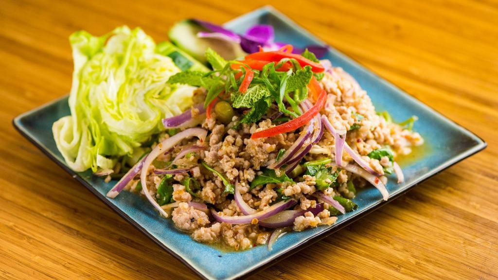 Laab Moo · Minced pork w/ ground toasted rice, coriander, red onion and mint leaves; seasoned w/ chili powder, fish sauce and fresh lime juice.