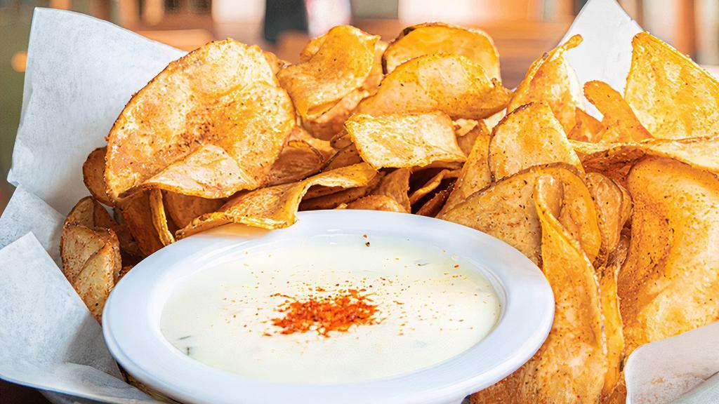 Old Bay Kettle Chips With Queso · This addictive shareable is perfect for the whole team.  Our veteran crispy kettle chips seasoned with Old Bay served alongside our creamy queso loaded with jalapenos and peppers for dipping. (1520 cal.)