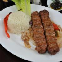  Adana Kebab · Char-grilled two skewers of ground lamb with seasonings. Served with rice pilaf and garnish.