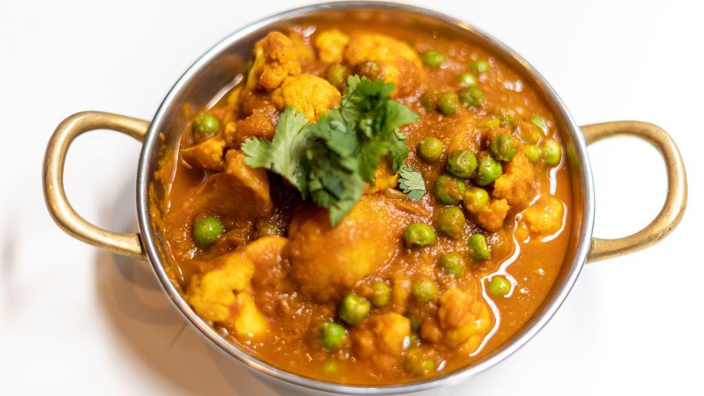 Aloo Gobi Matar · Stir fried cauliflower, baby green pea, potato, garlic, and cumin. Server with basmati rice. Vegan.