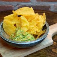 Guacamole And Chips · Guacamole is made with charred jalapeno, cilantro, tomato, red onions, lime, salt and pepper...