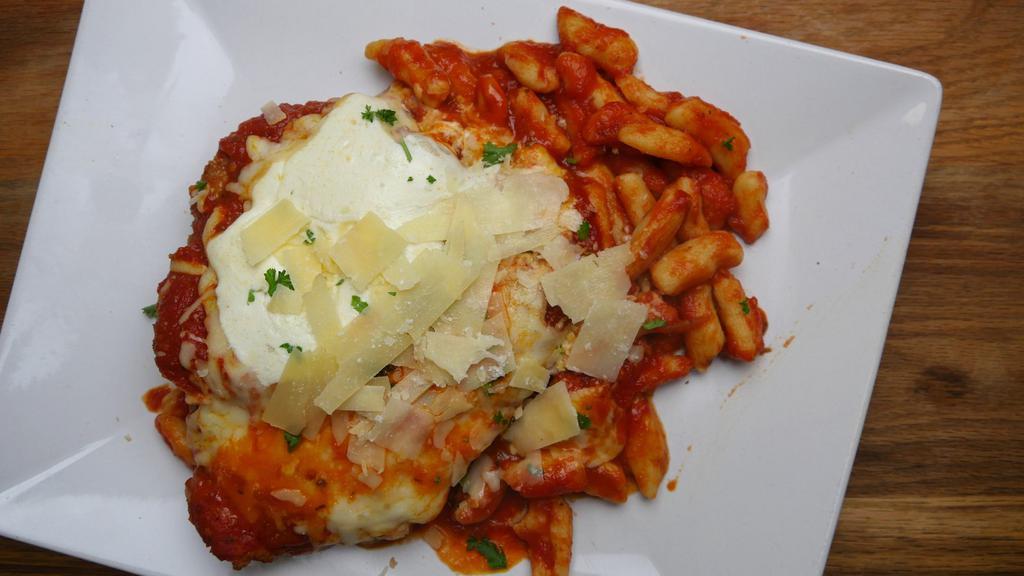 Chicken Parmigiana · Breaded chicken cutlet topped with fresh mozzarella and marinara over spaghetti.