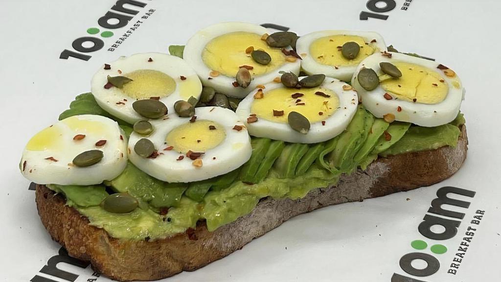 Spicy Avocado Sourdough Toast · *Hamotzi* toasted sourdough bread, freshly sliced avocado on a layer of smashed avocado, topped with sliced egg, chili flakes, pumpkin seeds, olive oil, salt & pepper.