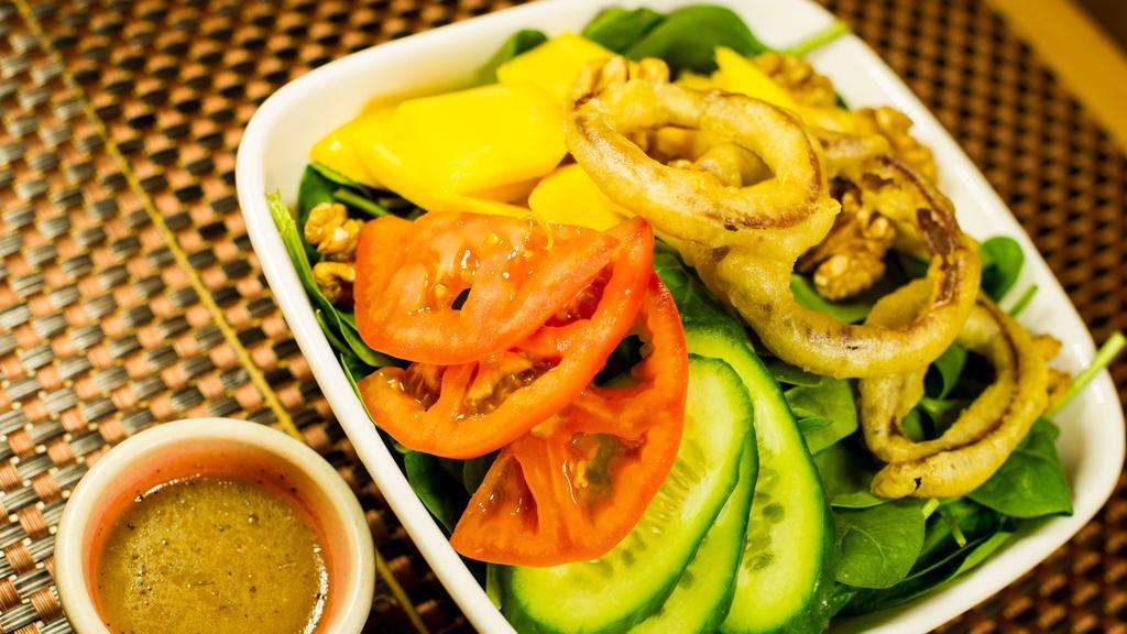 Mango Spinach Salad · Soy Free Option and Gluten free option. Chopped mango & spinach accented with battered onions & walnuts.