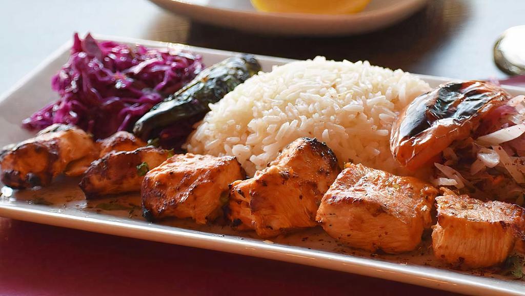 Chicken Shish Kebab · Skewered cubes of marinated char-grilled chicken served  with rice a red cabbage, onion salad and homemade bread.