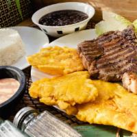Ribeye - Carne Asada · Ribeye Steak served with black beans, white rice, and green plantains.
Carne Asada acompanad...