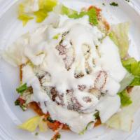 Tostada · Flat crispy corn tortilla topped with refried beans, lettuce, sour cream, Cotija cheese, pic...