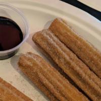 Churros · Fried pastry dough rolled in cinnamon sugar served with chocolate Abuelita compote.