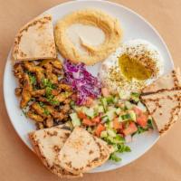 Vegan Shawarma Platter · Hummus, labneh, cabbage salad, Israeli salad and whole wheat pita.