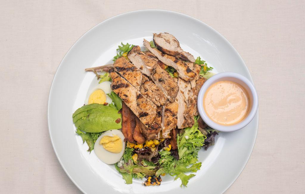 Cobb Salad · Mixed greens, grilled chicken, hard boiled eggs, smoked bacon, roast corn, avocado and crumbled blue cheese with chipotle ranch dressing.