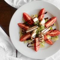 Caprese Salad · Fresh mozzarella and tomatoes topped with basil and extra virgin olive oil. Finished with ba...