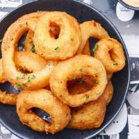 Onion Rings · Juicy white onions battered and fried to a crispy perfection served with our Crack Sauce.
