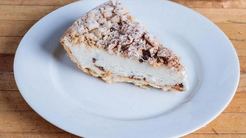 Cannoli Pie Slice · A flakey crust made of cannoli shell filled to the brim with cannoli cream. Each pie is topped with a dusting of powdered sugar, cocoa powder a sprinkle of mini-chocolate chips. Sweet enough to satisfy but not too much to overwhelm the experience.