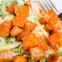 Buffalo Blue Salad · Crispy chicken tenders tossed in your choice of hot sauce, served over lettuce, tomato, onio...