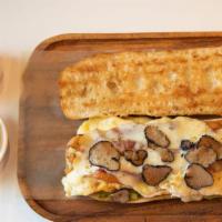 ..All Day Brunch-Clette Sandwich · Butter toasted baguette, fried eggs, bacon, guacamole, raclette cheese, and black truffles. ...
