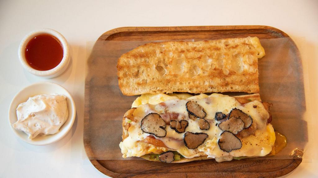 ..All Day Brunch-Clette Sandwich · Butter toasted baguette, fried eggs, bacon, guacamole, raclette cheese, and black truffles. Served on a home-baked baguette.