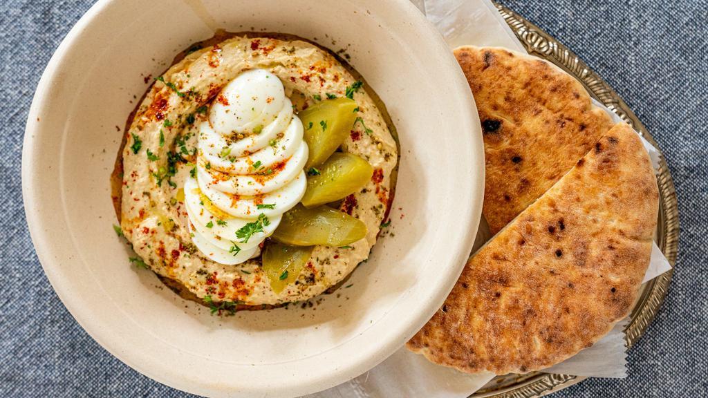 Hummus Plate · Fresh daily homemade hummus, tahini, Mediterranean herbs and spices, served with warm pita bread.