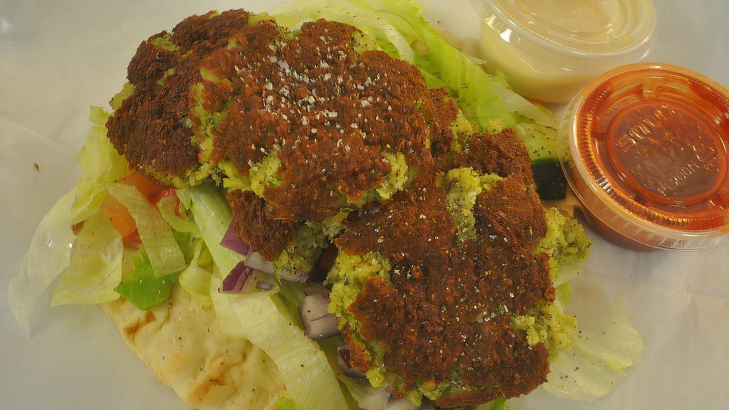 Falafel Gyro · Pita bread with lettuce, onions, tomatoes and cucumbers. Fresh ground chick peas with vegetables and added Mediterranean spices with sauce.
