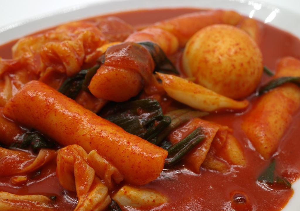 Tteokbokki (떡볶이) · Sticky rice cake, fish cake, cabbage, onion, spring onion, Korean pepper paste.