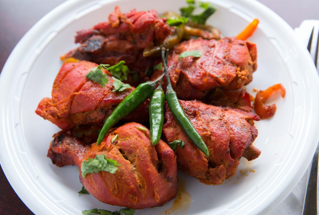 Chicken Tandoori · Gluten-free. Flavorful chicken drumsticks marinated and cooked in a traditional clay oven and served with a side of basmati rice.