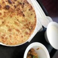 Aloo Paratha · Vegan. Flat bread stuffed with tender potatoes served with a side of yogurt.
