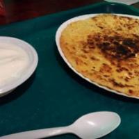 Paneer Paratha · Flat bread stuffed with traditional Indian cheese and served with a side of yogurt.