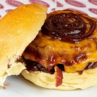 Cowboy Burger · Six ounces black angus, cheddar, bacon, onion rings, bbq sauce on a brioche bun.