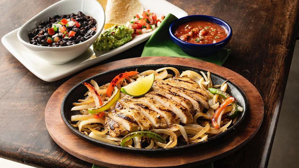 Border Smart Chicken Fajitas · Mesquite-grilled chicken with sautéed onions and bell peppers. Served with black beans, white corn tortillas, pico de gallo and guacamole.